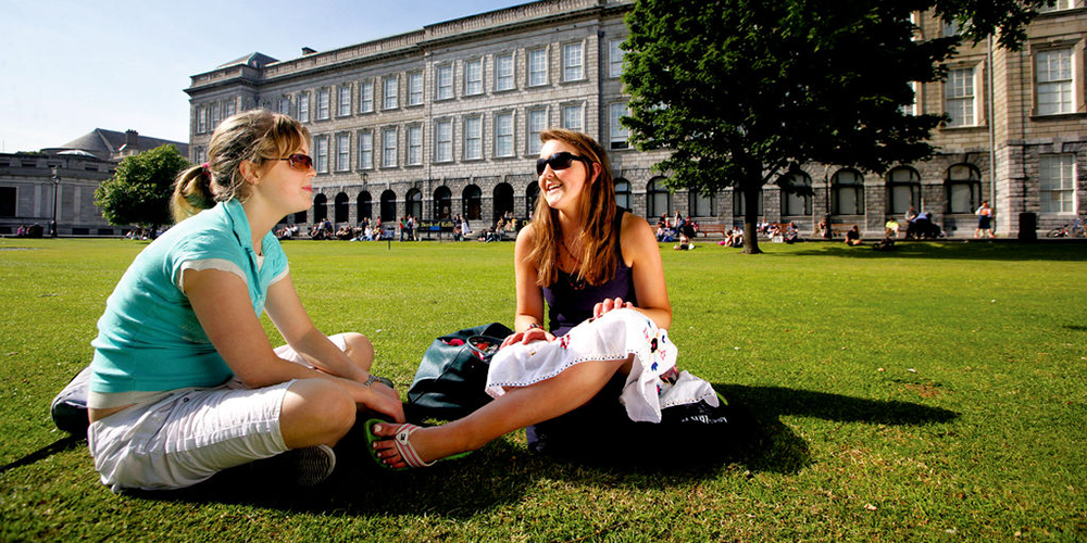 People sitting outside Trinity College, Dublin